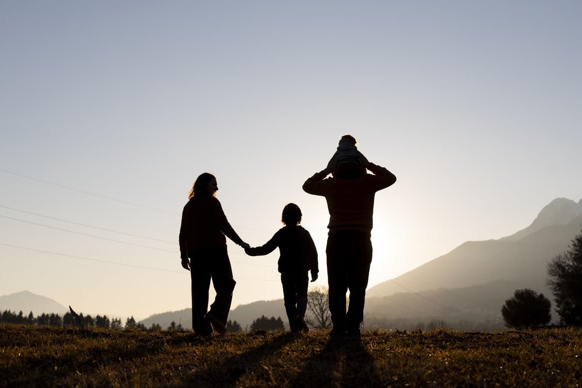 Family silhouettes enjoying nature at sunset